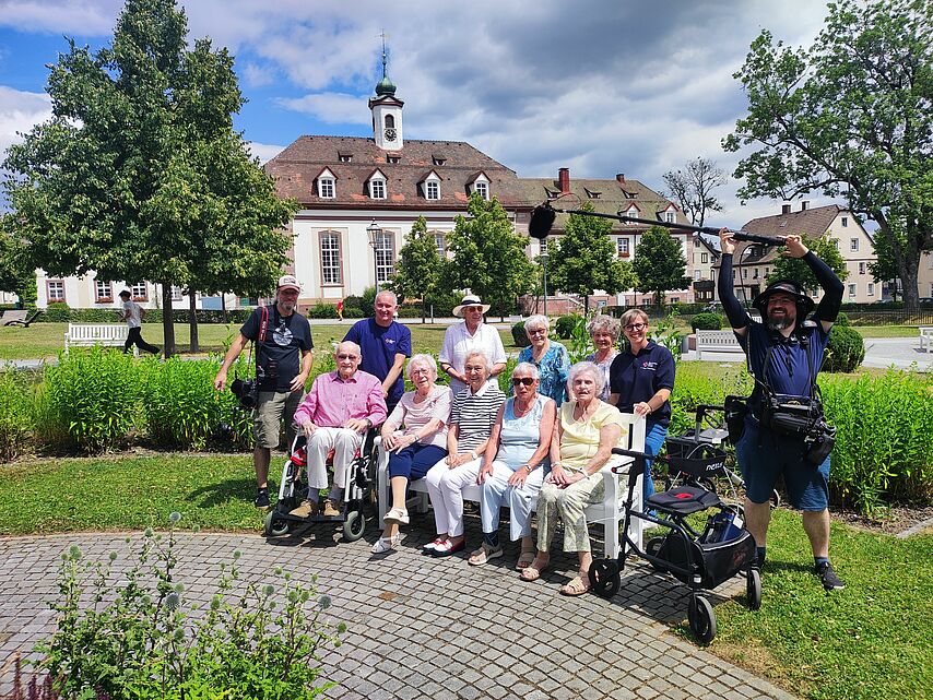Gruppenbild mit 10 Senioren und einem Fotografen mit Kamera